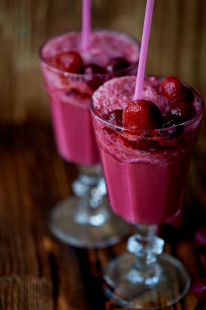 Fresh cool smoothie in a glass with a stem. Delicious and healthy Breakfast. Of cherries and strawberriesの写真素材