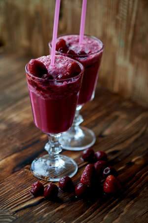 Fresh cool smoothie in a glass with a stem. Delicious and healthy Breakfast. Of cherries and strawberriesの写真素材