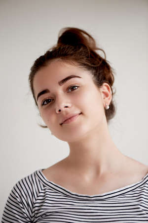 Young beautiful brunette with brown eyes and black hair. Smiling a satisfied smile. To settle forの写真素材