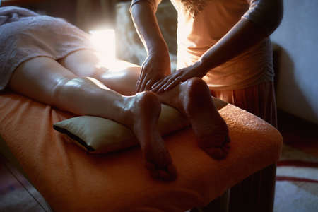 Foot massage in the spa salon. Close up of female feet during traditional Thai massageの写真素材
