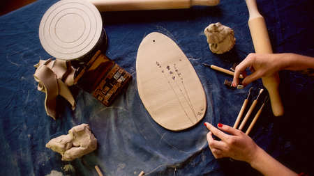 master shapes pottery on a blue canvas. Creative process. Gives shape to your product.Spread the...