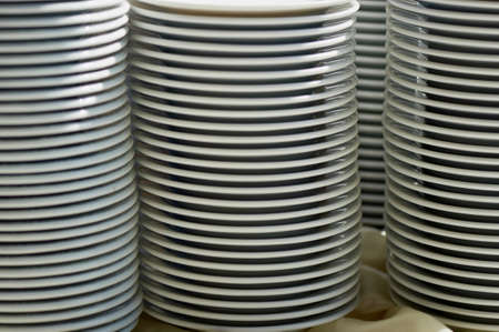 plates stacked on a table. Set of white dishes on table on light backgroundの写真素材