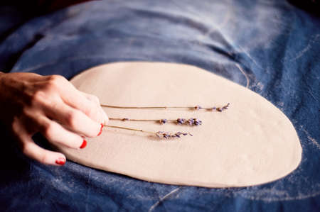 Creative workshop of ceramist. The imprint of grass on clay. Technique printed pattern. Workflow