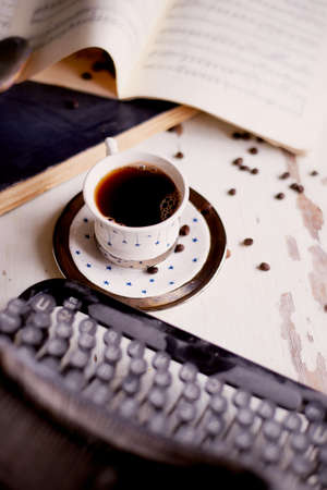 Old metal typewriter, covered in dust and rust. Cup of coffee on the table. The atmosphere of comfort and creativity. Retroの写真素材