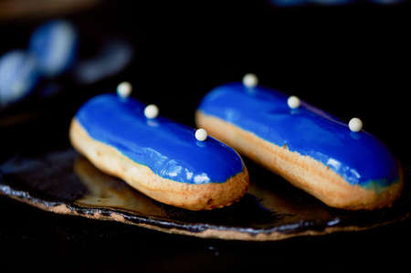 Blue eclairs with a mirrored glaze. A work of culinary art. Cakesの写真素材