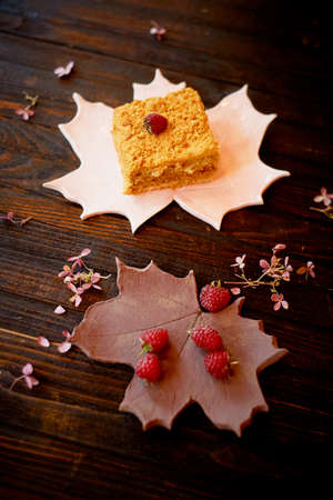 A piece of sweet honey cake on a plate in the form of a maple leaf. Cakesの写真素材