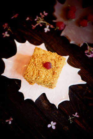 A piece of sweet honey cake on a plate in the form of a maple leaf. Cakes