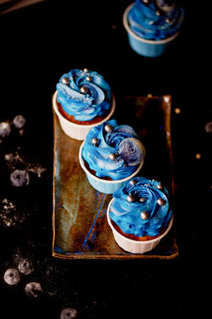 Incredible cosmic blue cupcakes with decoration in the form of round planets. A work of culinary artの写真素材