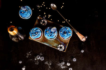 Incredible cosmic blue cupcakes with decoration in the form of round planets. A work of culinary artの写真素材