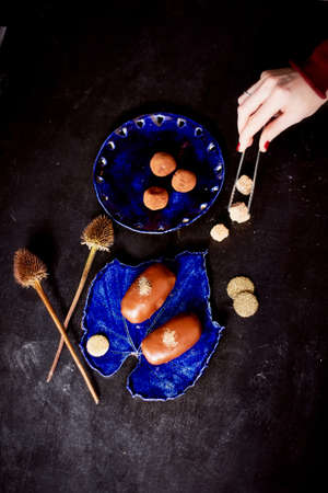Chocolate potato cake with gold powder on the deep blue plate. A work of culinary artの写真素材
