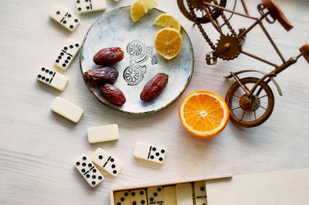 Fun atmosphere of a cozy evening eating dates, oranges, dominoes and dreams about travelの写真素材