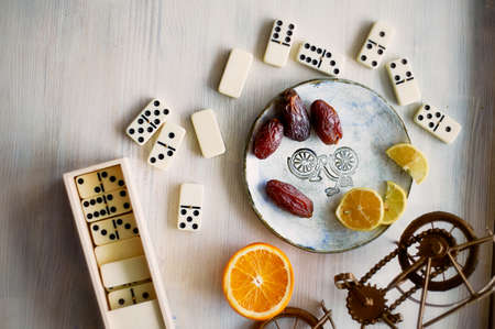 Fun atmosphere of a cozy evening eating dates, oranges, dominoes and dreams about travelの写真素材