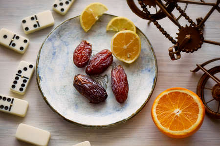 Fun atmosphere of a cozy evening eating dates, oranges, dominoes and dreams about travelの写真素材