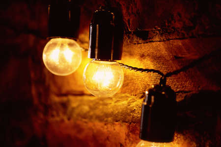 Edison light bulb hanging on a long wire. Cozy warm yellow light. Retroの写真素材