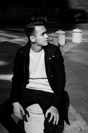 A young man, thin. With dark hair and brown eyes. Portrait. The model of attractive appearance. The concept of people in the city. Lifestyleの写真素材