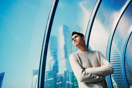 A young man, thin. With dark hair and brown eyes. Portrait. The model of attractive appearance. The concept of people in the city. Lifestyle. Hard light, shadowsの写真素材