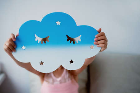 Pretty cute girl 4 years holding a cloud, the Territory of imagination and childhood.の写真素材