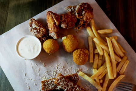 Hearty, fatty dish to the table. Cheese balls, fries and garlic croutons. Beerの写真素材