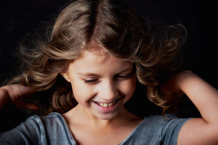 kinky girl with long hair. In the Studio on a black background. A fairy tale for children. Lives in the frameの写真素材