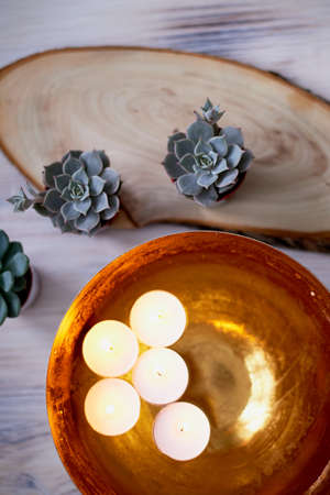 Golden bowl with water in which floating candles. Interior decoration for a relaxed atmosphereの写真素材