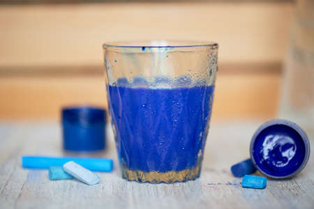 The glass with blue water, with dissolved paint. Drawingの写真素材