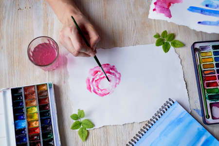 The process of creating an illustration by the artist. Watercolor paint. Hand with brushの写真素材