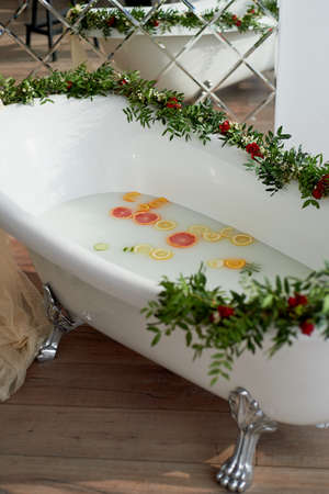 Elegant roll-top bath and decorated with flowers. In the water swim citrus. The atmosphere of relaxation, relaxationの写真素材