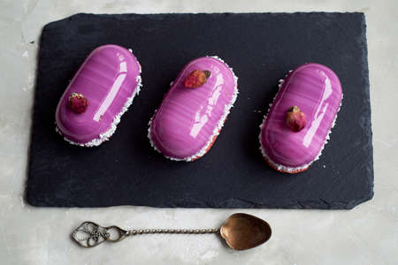 Three beautiful mousse cakes covered with mirror shiny glaze. The skill of the pastry chefの写真素材