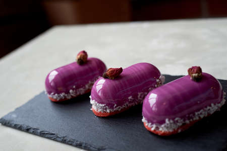 Three beautiful mousse cakes covered with mirror shiny glaze. The skill of the pastry chefの写真素材