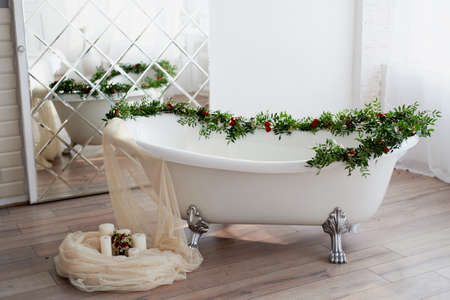 Bath on lions paws, decorated with flowers. On the floor are candles. A romantic setting for a dateの写真素材