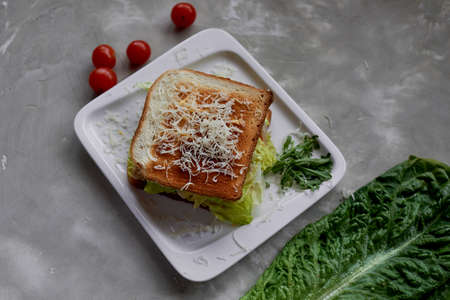 A delicious sandwich with salad and chicken. Sprinkled with cheese. A quick delicious Breakfastの写真素材