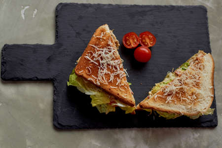 A delicious sandwich with salad and chicken. Sprinkled with cheese. A quick delicious Breakfastの写真素材