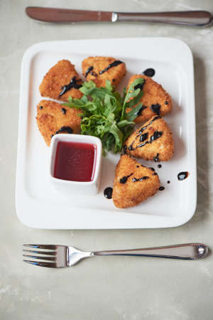Camembert in batter, deep fried, with balsamic vinegar and arugulaの写真素材