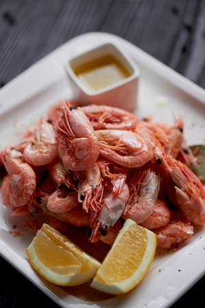 Boiled shrimp with pepper and Lavrushka. With the lemon slices and sauceの写真素材