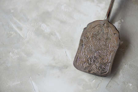 Antique old appliances. Forceps for feeding the cake on a concrete backgroundの写真素材