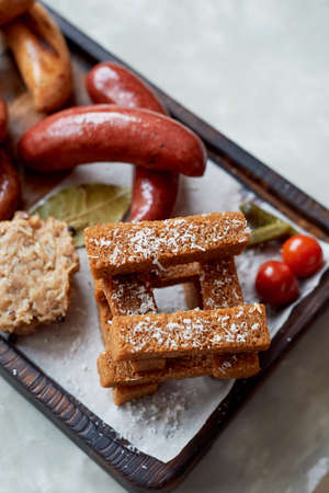 German hearty lunch in the pub. Grilled sausages, stewed cabbage, croutons, sauce. Beer snackの写真素材
