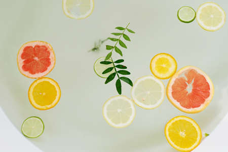 Milk water in the bath, which swim citrus: lime, lemon and grapefruit. Skin care and relaxationの写真素材
