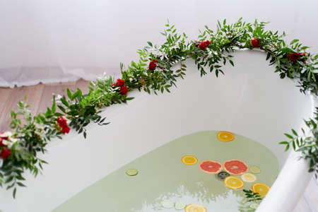 Elegant roll-top bath and decorated with flowers. In the water swim citrus. The atmosphere of relaxation, relaxationの写真素材