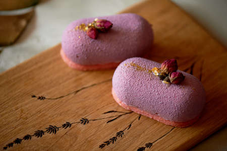 Beautiful fruit mousse cake lilac on a wooden Board with a pattern