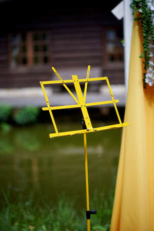 Arch for wedding ceremony in the open air, decorated with yellow fabric and flowers.Details closeの写真素材