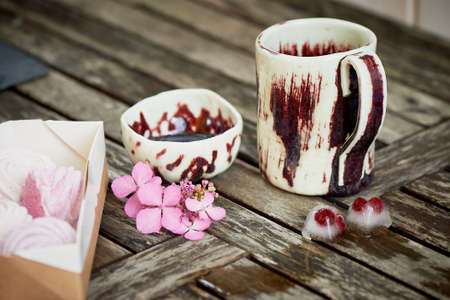 Handmade ceramics. Ice cubes, frozen berries, on wooden background. Freshness rustic