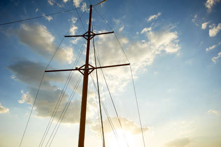 The wooden mast of an old ship on the background of blue sky. Going out to sea and adventures