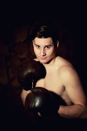 A young strong man trains in Boxing.Aggressiveness, sports and a healthy lifestyle.