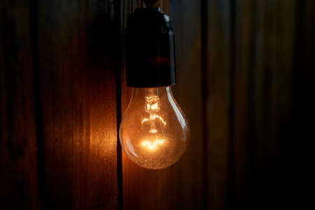 Edison light bulb hanging on a long wire. Cozy warm yellow light. Retroの写真素材