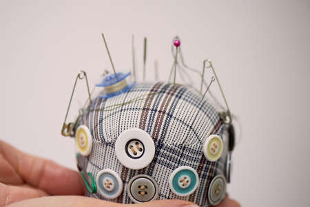 Plaid pin cushion in the hands of seamstresses. Handmade, sewing.の写真素材
