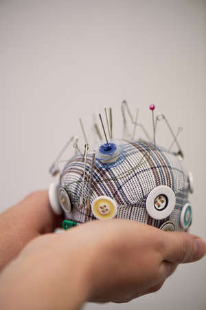 Plaid pin cushion in the hands of seamstresses. Handmade, sewing.の写真素材