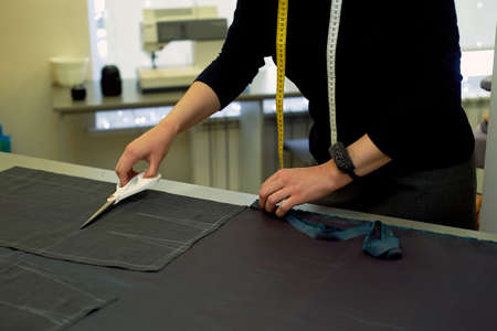 Master cuts fabric. Nesting. Suiting fabric marked with white chalk. Cutting and sewing