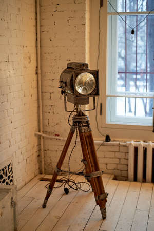 Old movie projector with a lens and a hot lamp. On a tripod.の写真素材