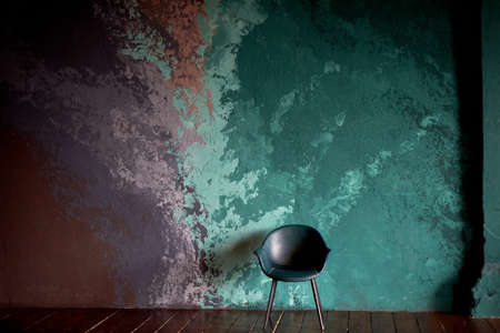 The chair on the textured background of the wall of turquoise and lilac. Smears. The style of minimalism.の写真素材