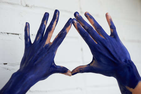 Hands in blue paint, the hands of the artist and creative person. Yoga for the hands.の写真素材